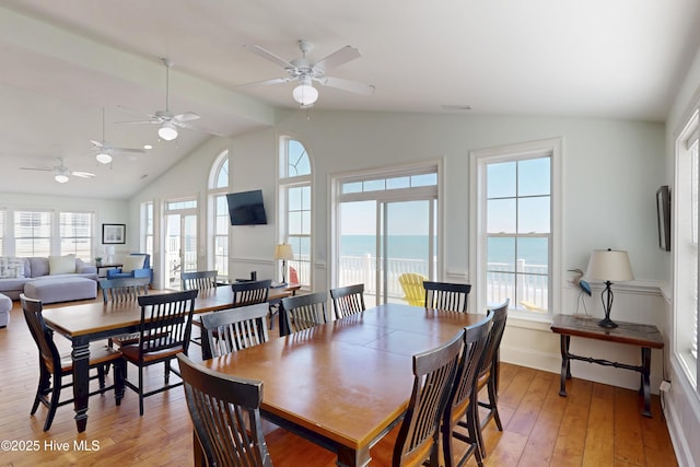 dining area with vaulted ceiling, light wood-type flooring, visible vents, and baseboards