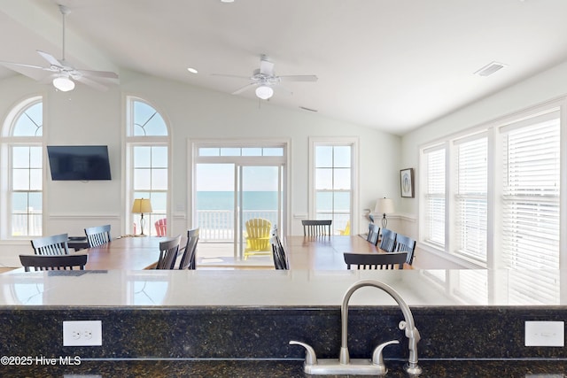 kitchen with lofted ceiling, ceiling fan, open floor plan, and a wealth of natural light