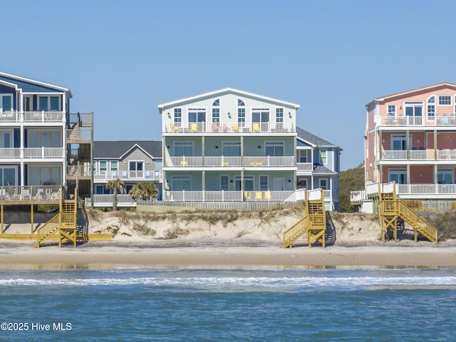 rear view of house with a view of the beach and a water view