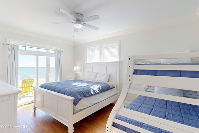 bedroom with ornamental molding, multiple windows, a water view, and wood finished floors