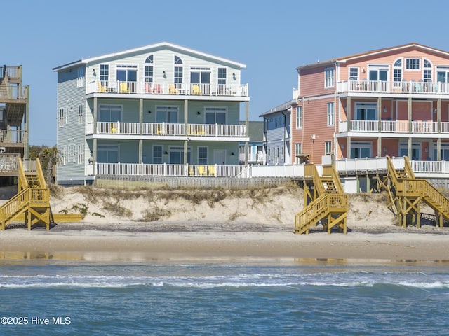 back of house featuring a view of the beach and a water view