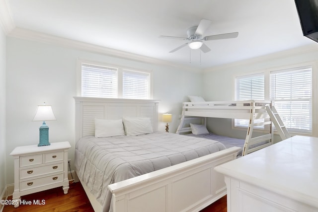 bedroom with ceiling fan, dark wood-type flooring, baseboards, and crown molding