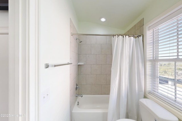 bathroom with toilet, shower / bath combination with curtain, and lofted ceiling