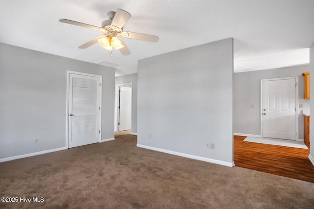 carpeted spare room featuring ceiling fan and baseboards