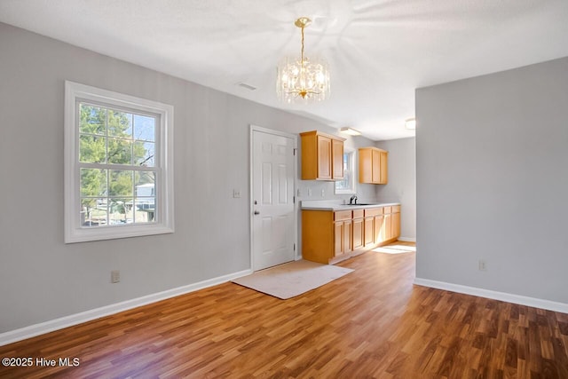 kitchen with visible vents, baseboards, light countertops, and wood finished floors