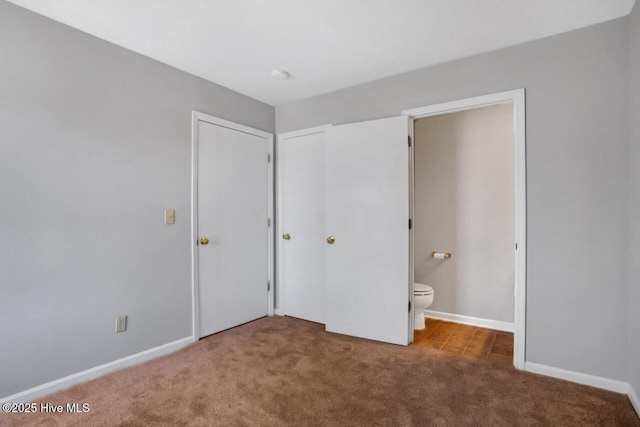 unfurnished bedroom with carpet floors, a closet, and baseboards