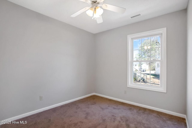 carpeted spare room with ceiling fan, visible vents, and baseboards