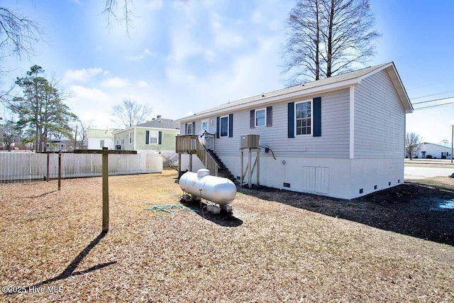 back of property with crawl space, fence, and central air condition unit