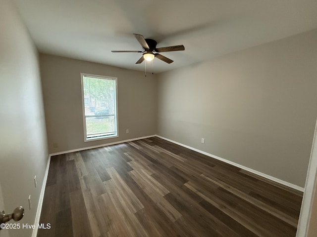 empty room featuring baseboards, ceiling fan, and dark wood-style flooring