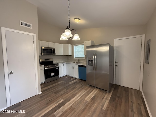 kitchen featuring a sink, appliances with stainless steel finishes, visible vents, a chandelier, and dark wood finished floors