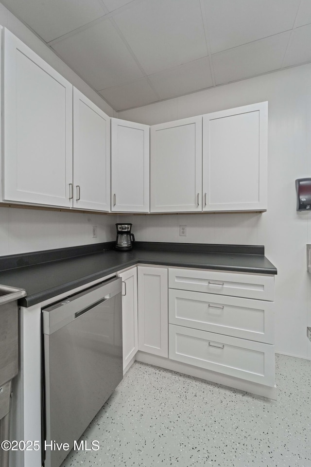 kitchen featuring dark countertops, white cabinets, dishwasher, and a paneled ceiling