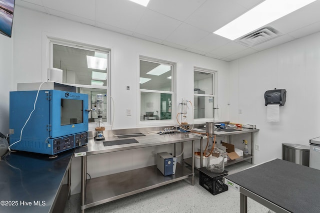 kitchen with stainless steel countertops, a drop ceiling, and visible vents