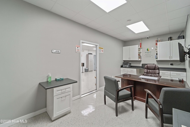 office area with a drop ceiling and baseboards