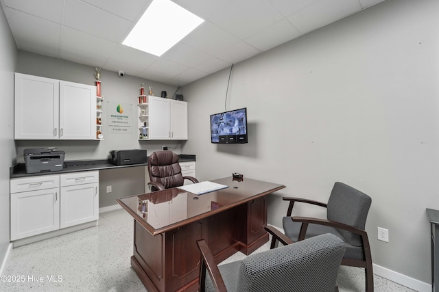 office featuring light speckled floor, a paneled ceiling, and baseboards