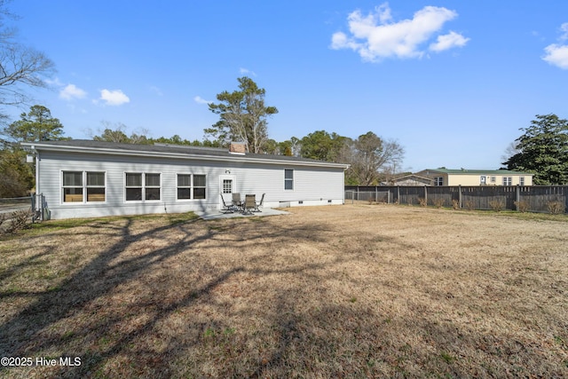 rear view of property featuring a yard, a patio, and fence