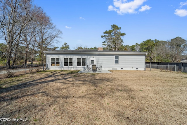 rear view of property featuring a fenced backyard, crawl space, a lawn, a chimney, and a patio area