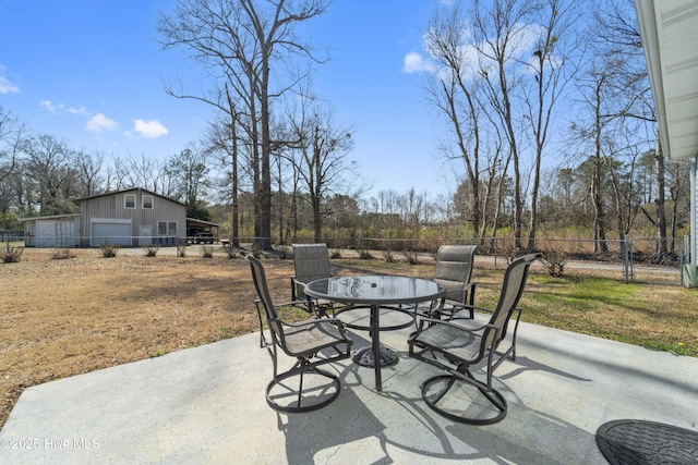 view of patio with an outbuilding, outdoor dining space, and a fenced backyard