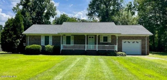 ranch-style home with covered porch, a front yard, and a garage