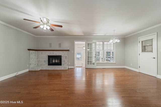 unfurnished living room with ceiling fan with notable chandelier, a fireplace, wood finished floors, and baseboards