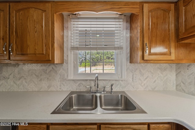 kitchen with brown cabinets, light countertops, and a sink