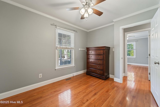 bedroom featuring light wood finished floors, visible vents, baseboards, a ceiling fan, and crown molding