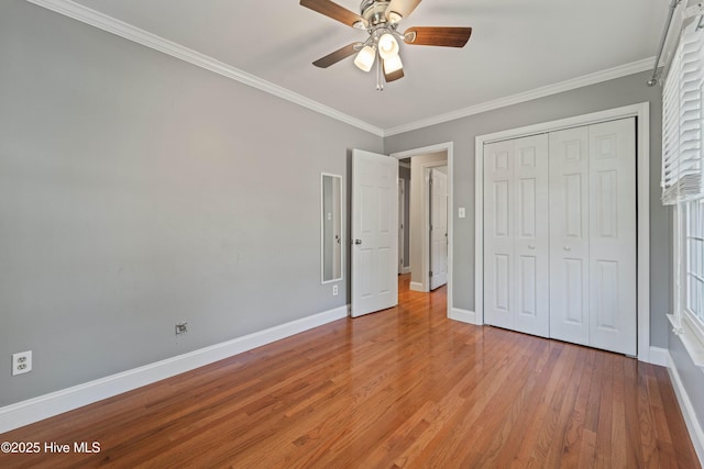 unfurnished bedroom with a ceiling fan, baseboards, ornamental molding, a closet, and light wood finished floors