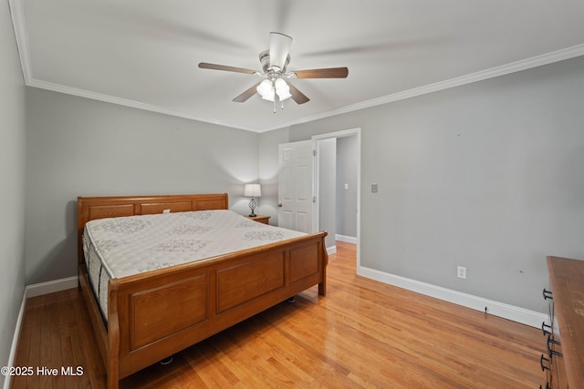 bedroom with light wood-style flooring, baseboards, and crown molding