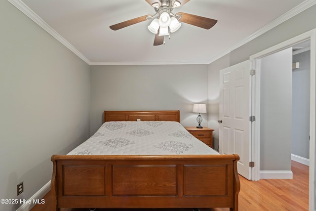 bedroom featuring baseboards, crown molding, and light wood-style floors