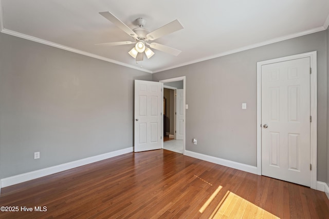 unfurnished room featuring ornamental molding, ceiling fan, baseboards, and wood finished floors