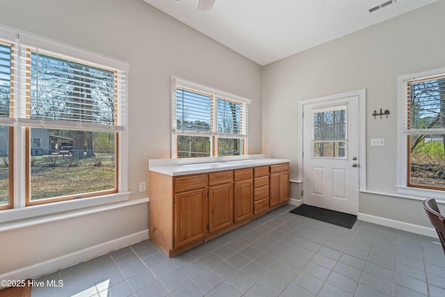 interior space with tile patterned flooring, visible vents, vanity, and baseboards