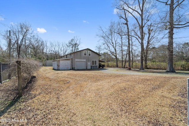 view of property exterior with a garage, an outbuilding, and driveway