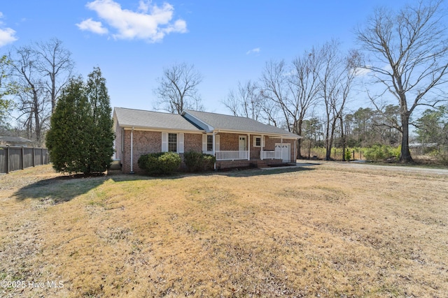 single story home with a garage, a porch, fence, a front lawn, and brick siding