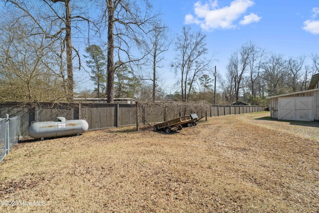 view of yard with a storage shed, fence, and an outbuilding