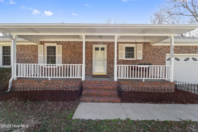 property entrance featuring covered porch, brick siding, and a garage