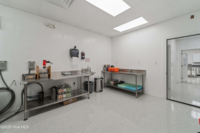 miscellaneous room featuring speckled floor and a drop ceiling