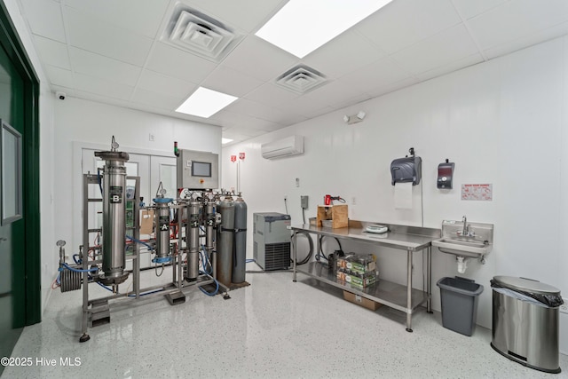 gym with visible vents, an AC wall unit, and a paneled ceiling