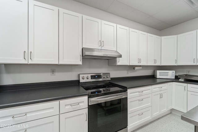 kitchen featuring stainless steel range with electric stovetop, dark countertops, under cabinet range hood, and white microwave