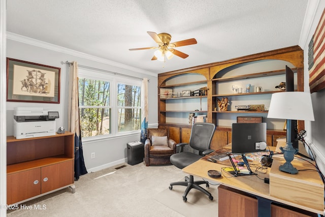 carpeted office featuring ceiling fan, ornamental molding, and a textured ceiling