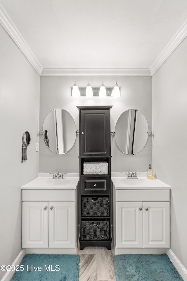 bathroom with a sink, ornamental molding, and two vanities