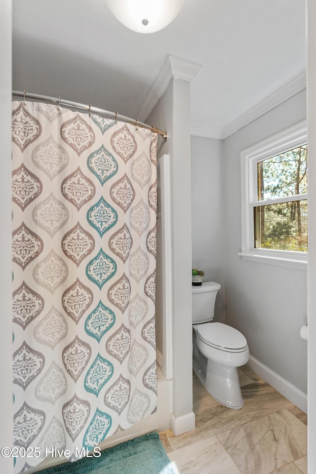 bathroom with ornamental molding, a shower with curtain, baseboards, and toilet