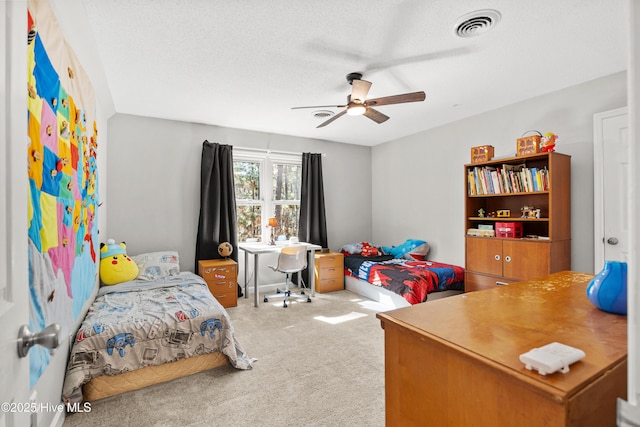 bedroom with carpet, visible vents, ceiling fan, and a textured ceiling