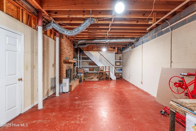 unfinished basement with concrete block wall and stairs