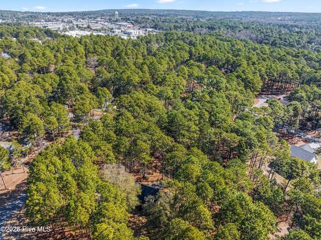 birds eye view of property featuring a forest view