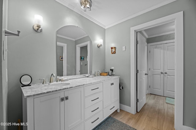 full bath featuring ornamental molding, double vanity, wood finished floors, and a sink