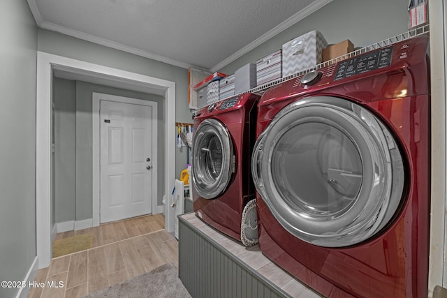 washroom with laundry area, wood tiled floor, crown molding, washer and dryer, and a textured ceiling