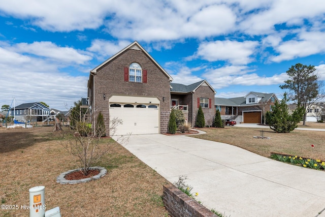 traditional-style house featuring a garage, a front yard, brick siding, and driveway