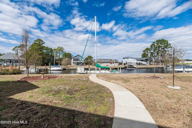 view of property's community featuring a yard, a boat dock, and a water view