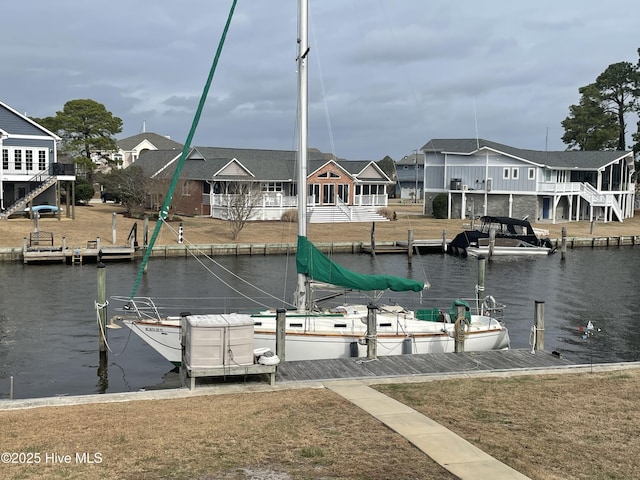 view of dock with a residential view and a water view