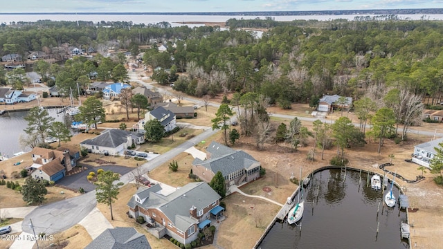 bird's eye view featuring a residential view, a water view, and a wooded view