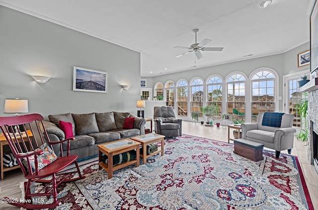 living room featuring a ceiling fan, wood finished floors, crown molding, a fireplace, and recessed lighting